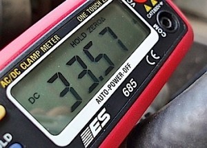 Photo 4: This inductive ammeter, which is clamped on the alternator's B+ output wire, indicates 33.57 amperes charging output. 